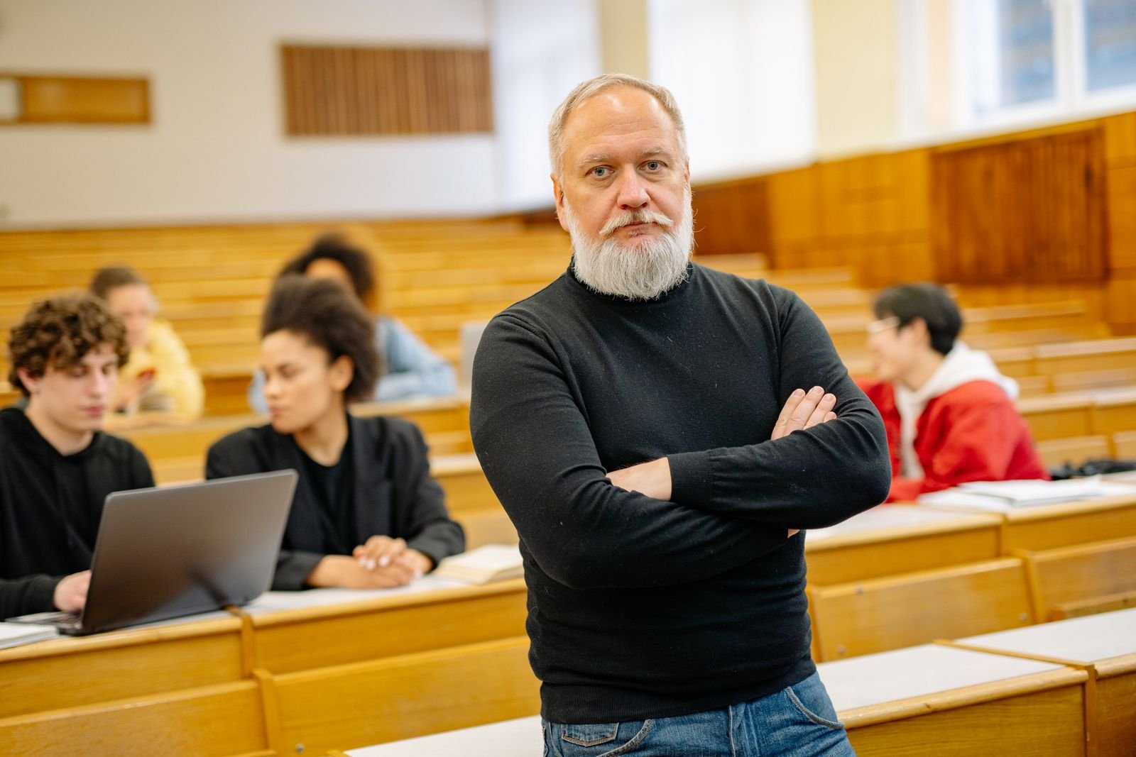 Mature teacher supporting students in a lecture hall